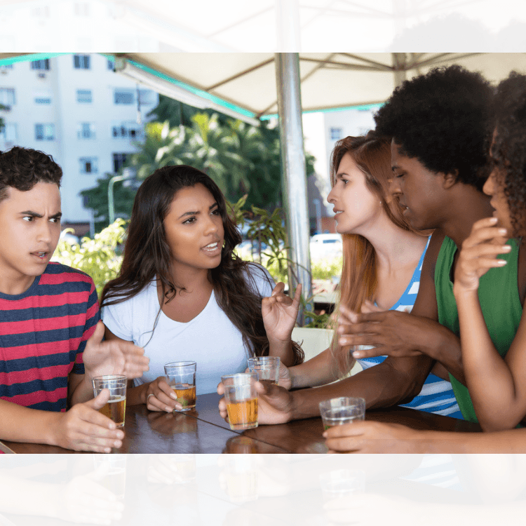 Photo d'un groupe de jeunes attablés à la terrasse d'un café, en pleine discussion.